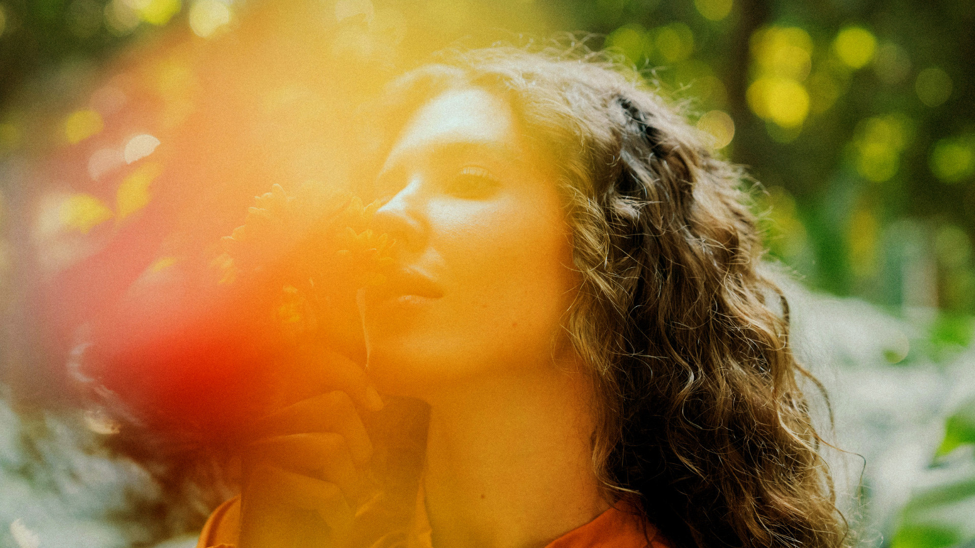 Woman in golden sunlight holding flowers